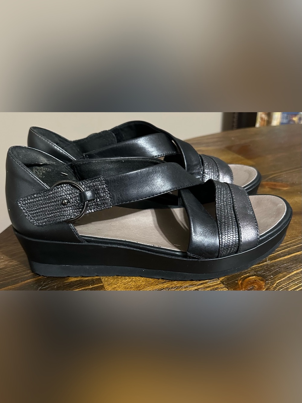 Earth Hibiscus Black Leather Wedge Sandals, featuring stylish crisscross straps